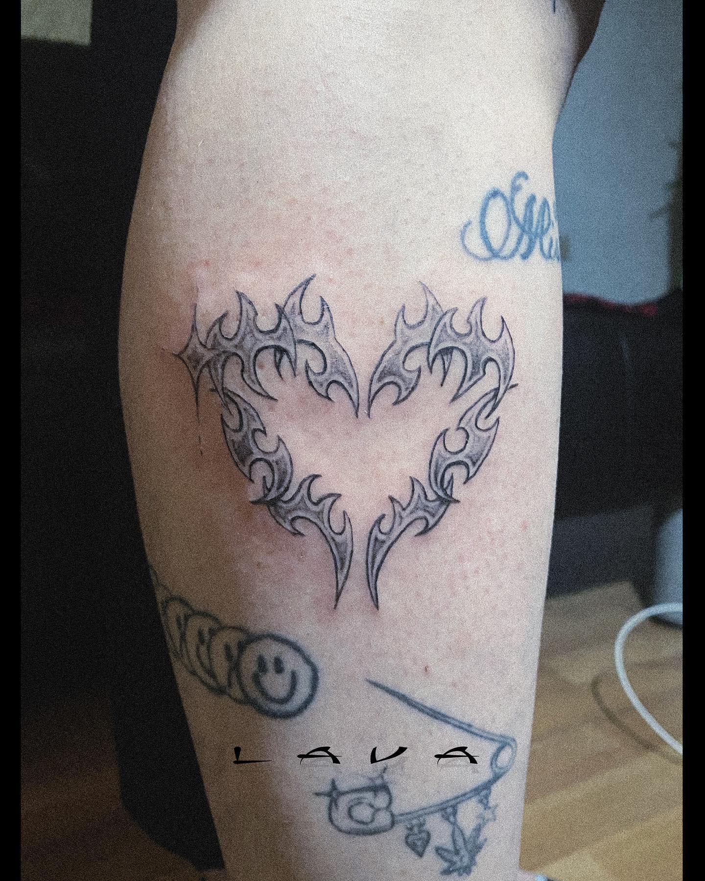 Tribal heart composed of flames, tattoo on calf, signed LAVA